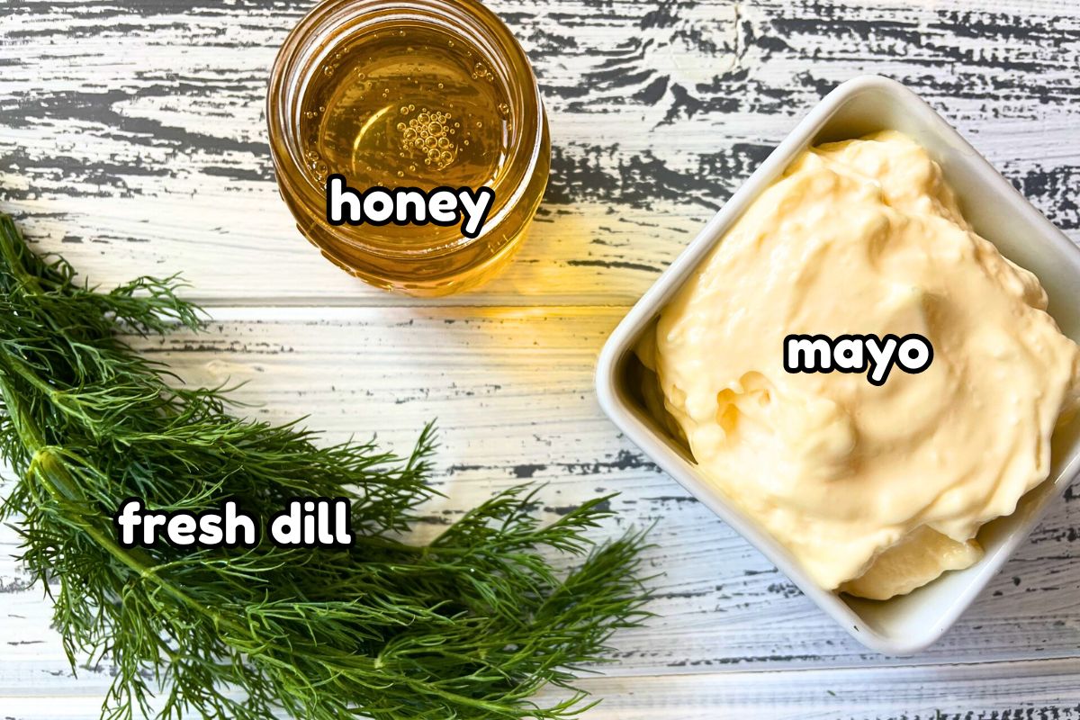 Honey dill sauce ingredients labeled on white wooden background.