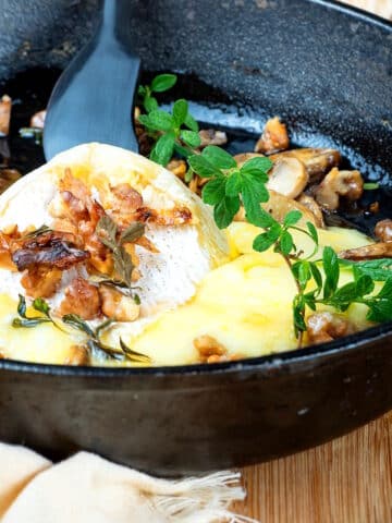 Melted brie cheese in cast iron pan.