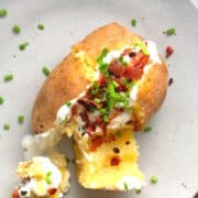 Baked and stuffed potato on plate.