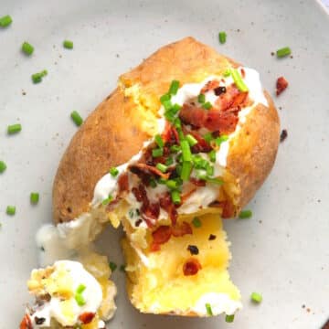 Baked and stuffed potato on plate.