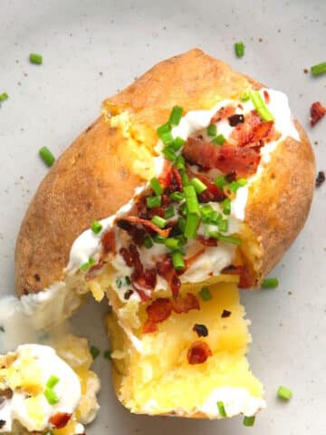 Baked and stuffed potato on plate.