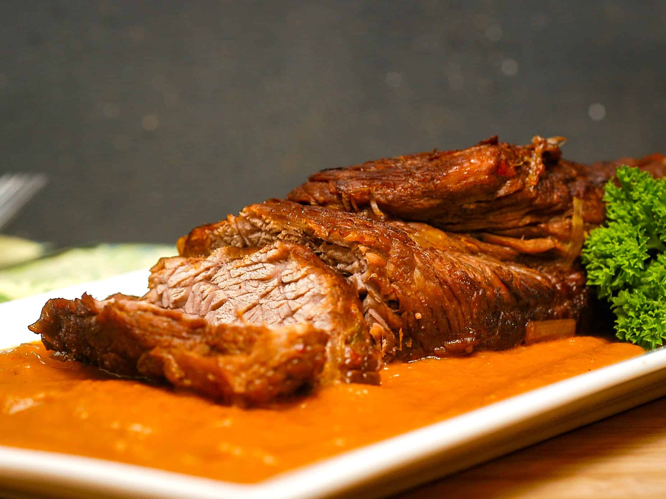Braised beef with pureed vegetables on white dish.