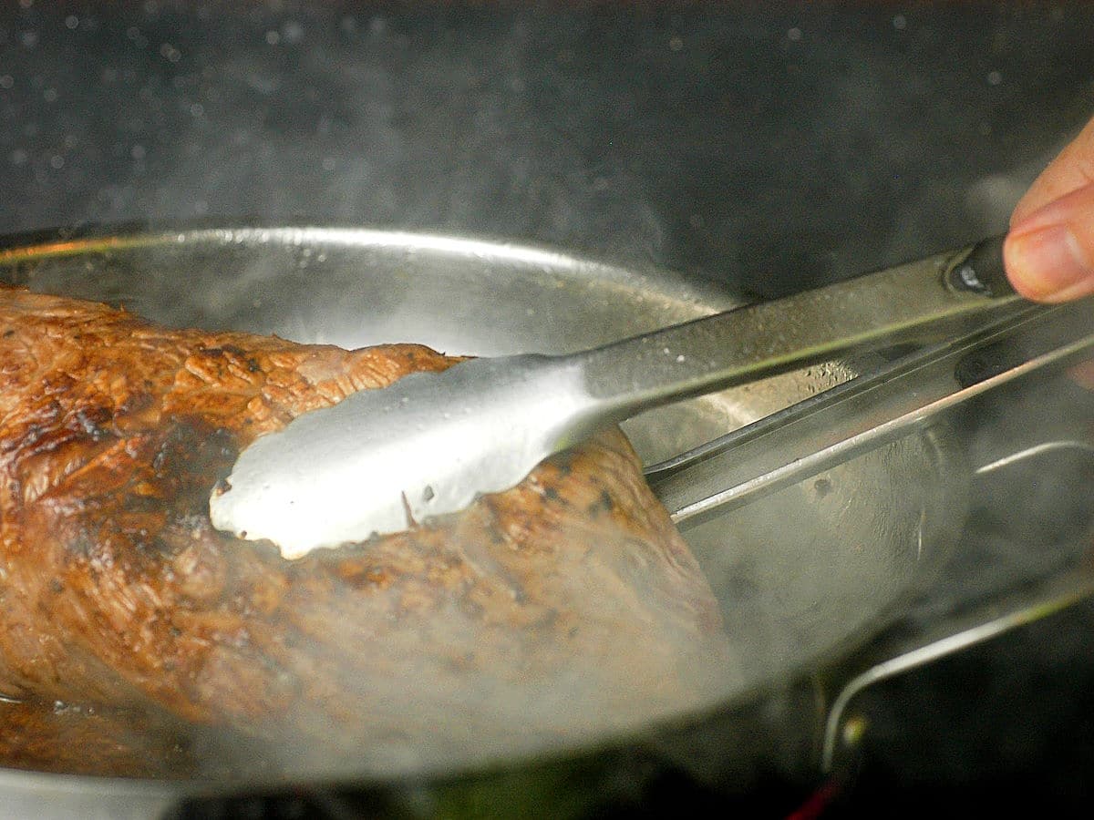 Beef roast seared in pan.