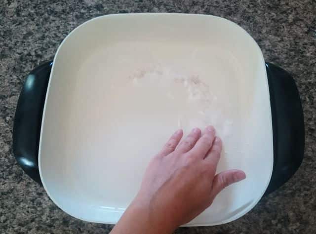 electric skillet baking soda paste Electric skillet with baking soda paste and a hand.