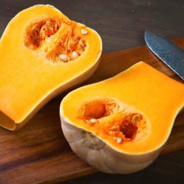 Butternut squash sliced open on cutting board.