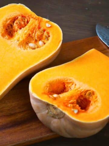 Butternut squash sliced open on cutting board.