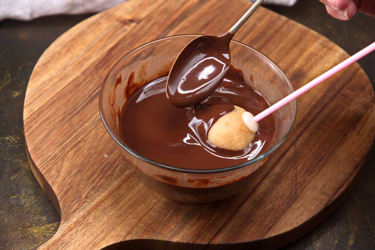 Cake pop in bowl of chocolate coating.