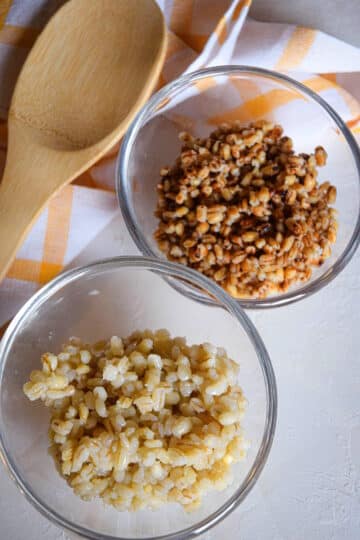 Cooked pearl and hulled barley in bowls.