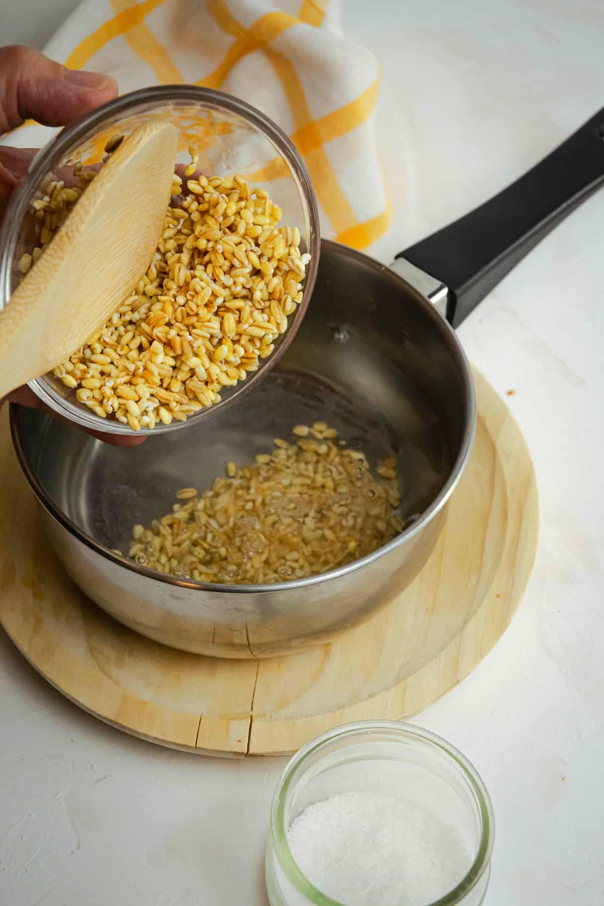 Uncooked barley in bowl and pot.