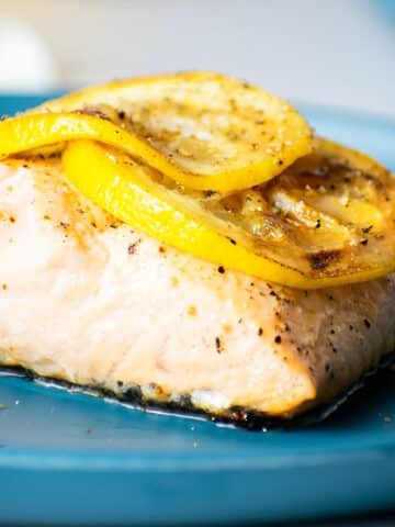 Salmon fillet with grilled lemon slices on top.