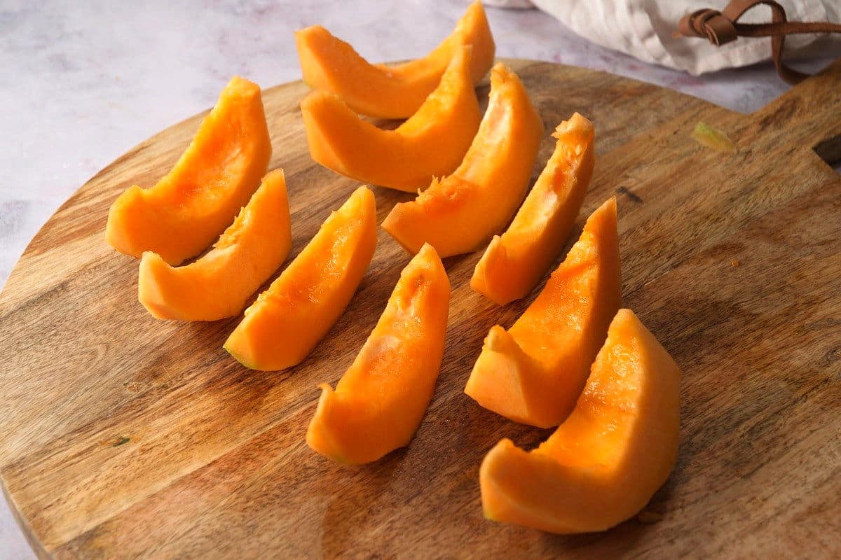 Cantaloupe wedges on cutting board.
