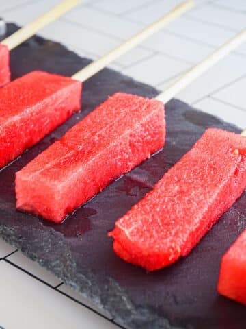Watermelon sticks on black stone.