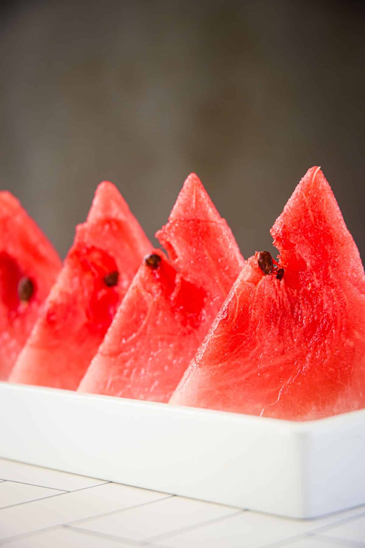 Watermelon triangles in white dish.