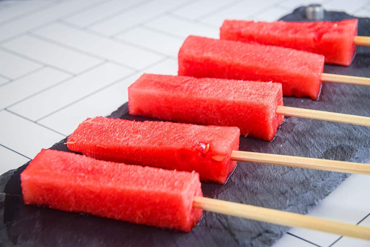 Watermelon sticks on popsicle sticks.