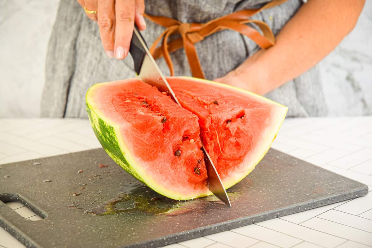 Watermelon getting sliced into wedges.