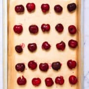 Fresh cherries on parchment lined sheet pan.