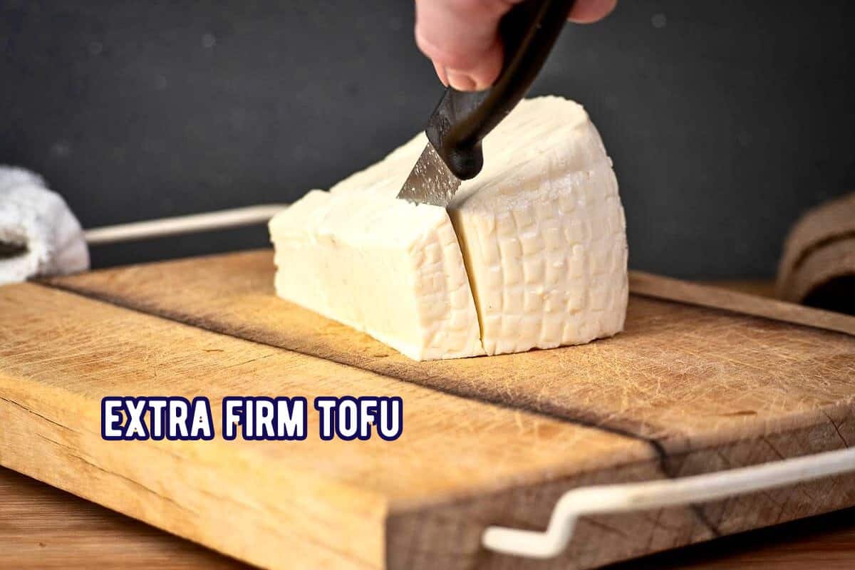 Firm tofu labeled with knife on cutting board.