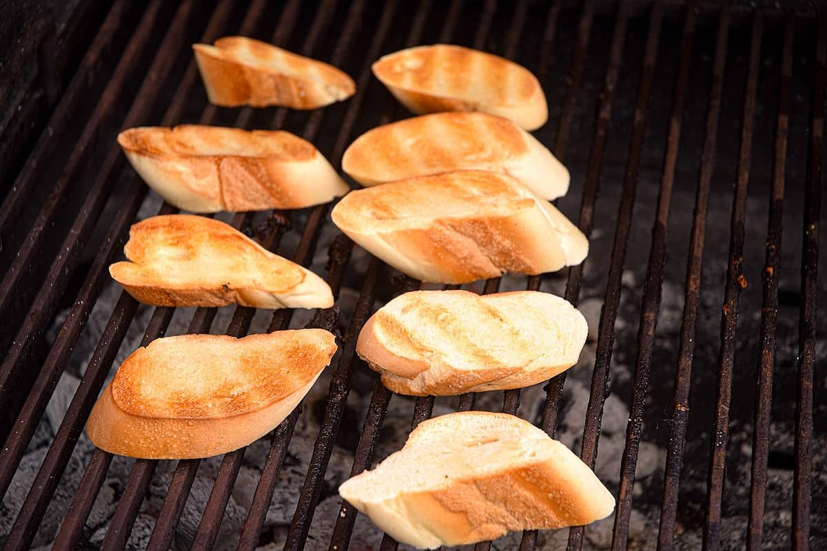 Bread slices on the grill with grill marks.