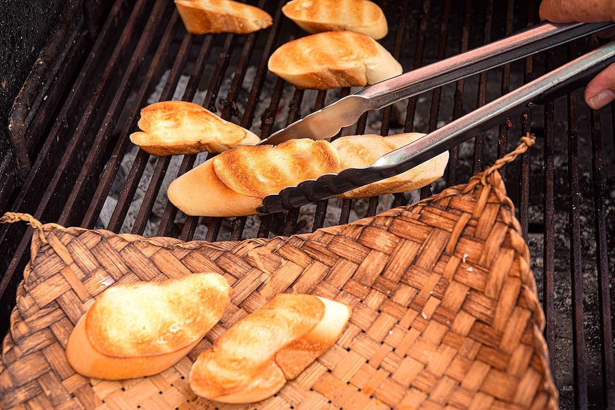 Grilled bread getting transferred to basket.