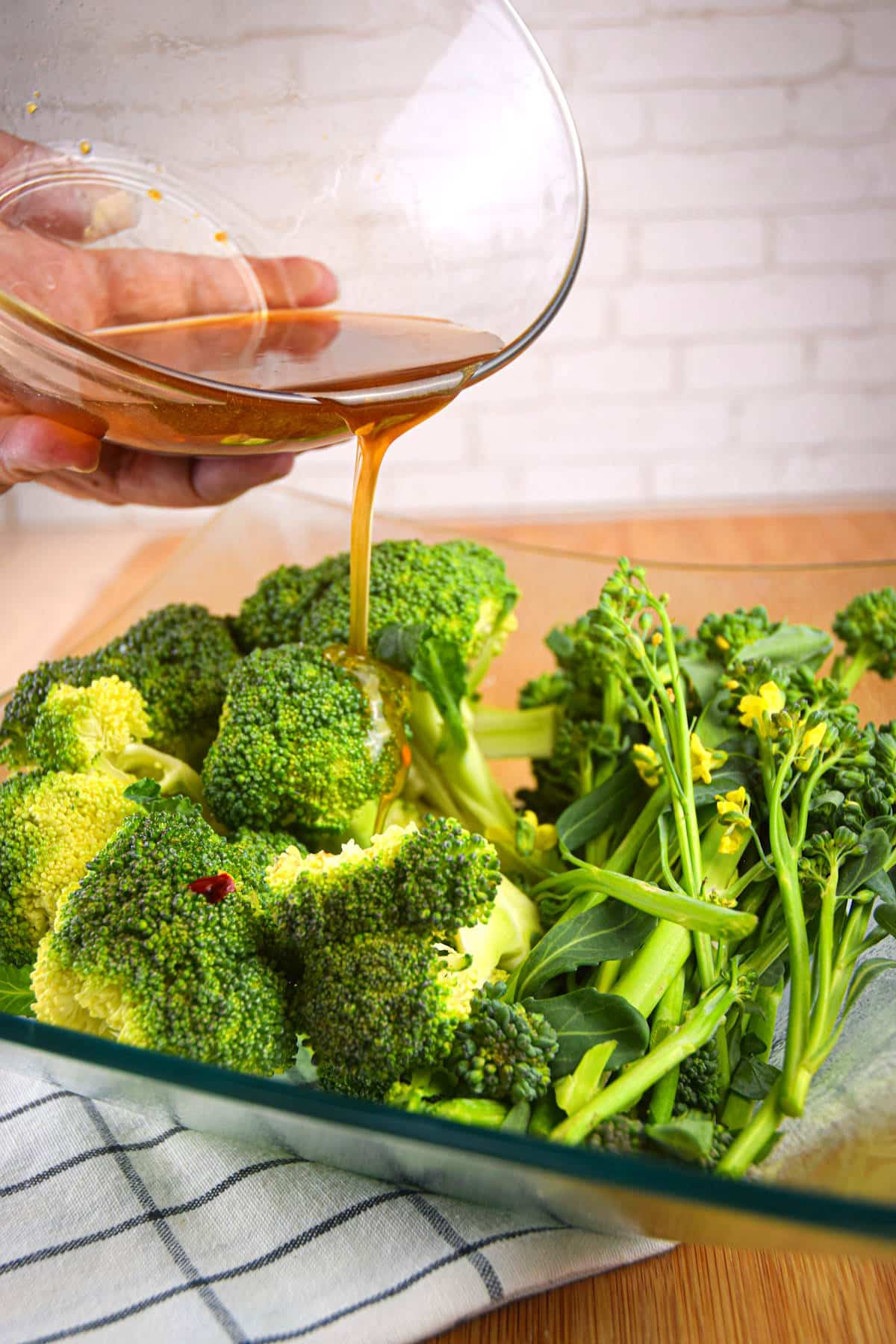 Marinade pouring over broccoli and broccolini.