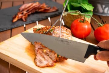 Carne asada steak getting sliced with chef's knife.