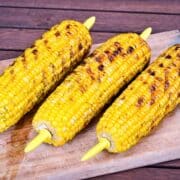 Grilled corn on wooden board.