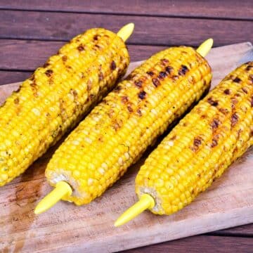 Grilled corn on wooden board.