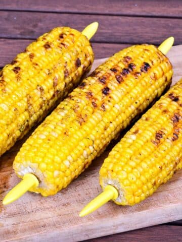 Grilled corn on wooden board.