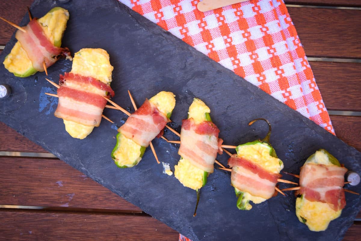 Grilled jalapeño poppers on serving board.
