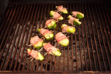 Uncooked jalapeño poppers on grill.
