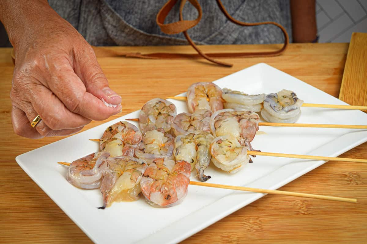 Raw jumbo shrimp on skewers.