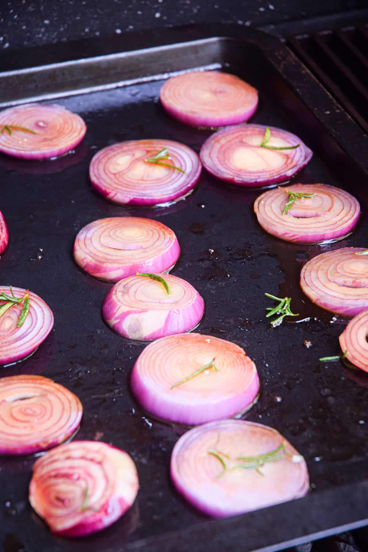 Red onion rings on sheet pan on the grill.