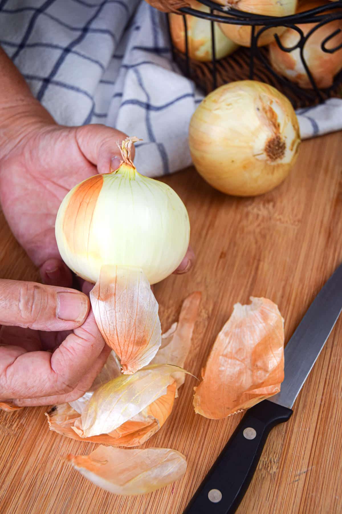 Yellow onion getting peeled.