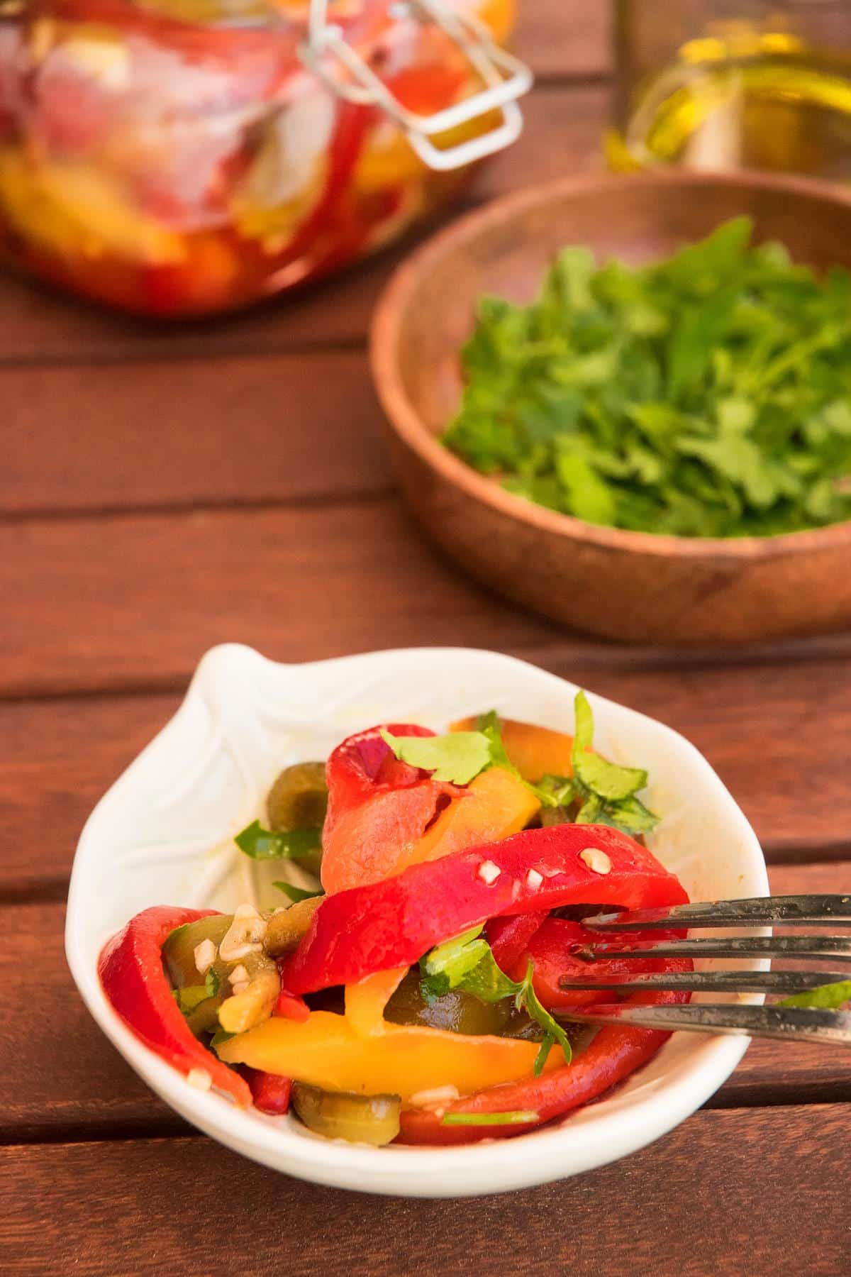 Grilled, sliced peppers in bowl with fork.