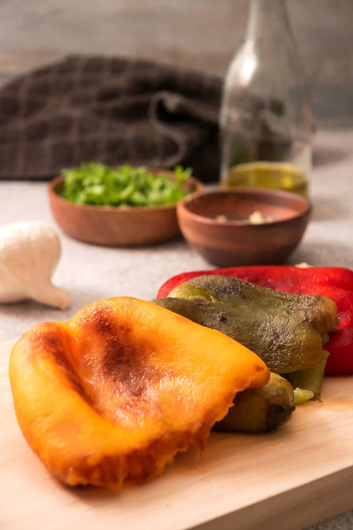 Grilled, peeled peppers on cutting board.