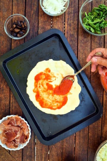 Pizza dough with tomato sauce.