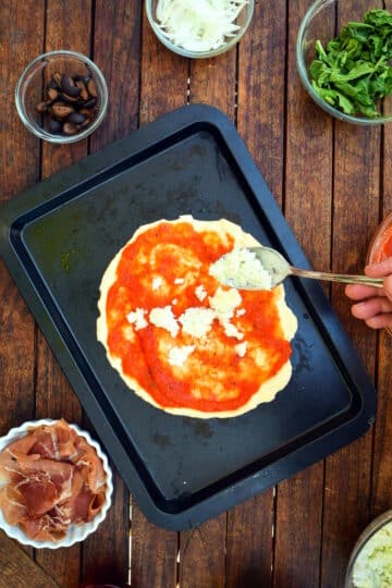 Pizza dough with sauce and cheese.