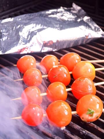 Skewered and foil-pack tomatoes on grill.