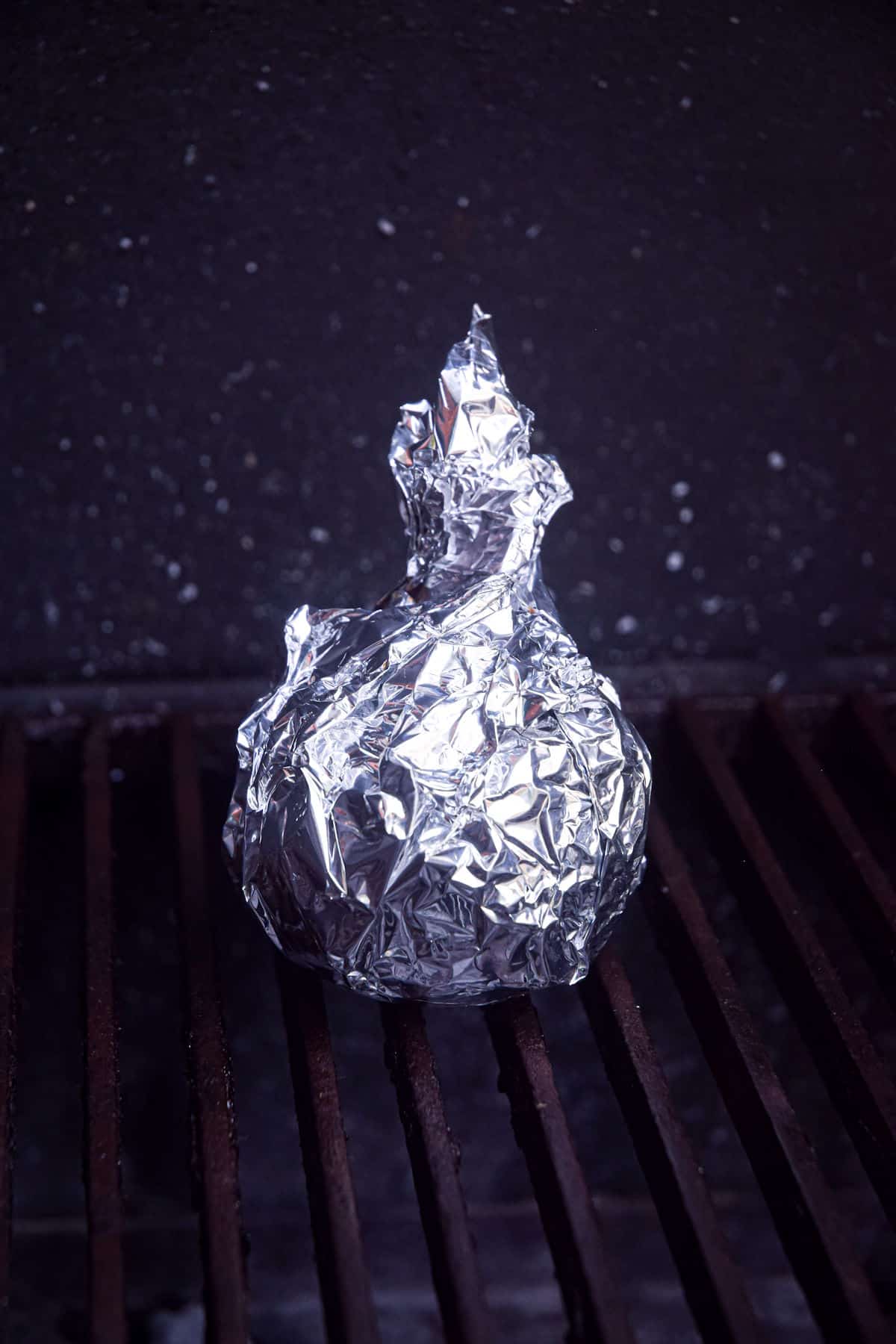 Foil-wrapped onion on grill.