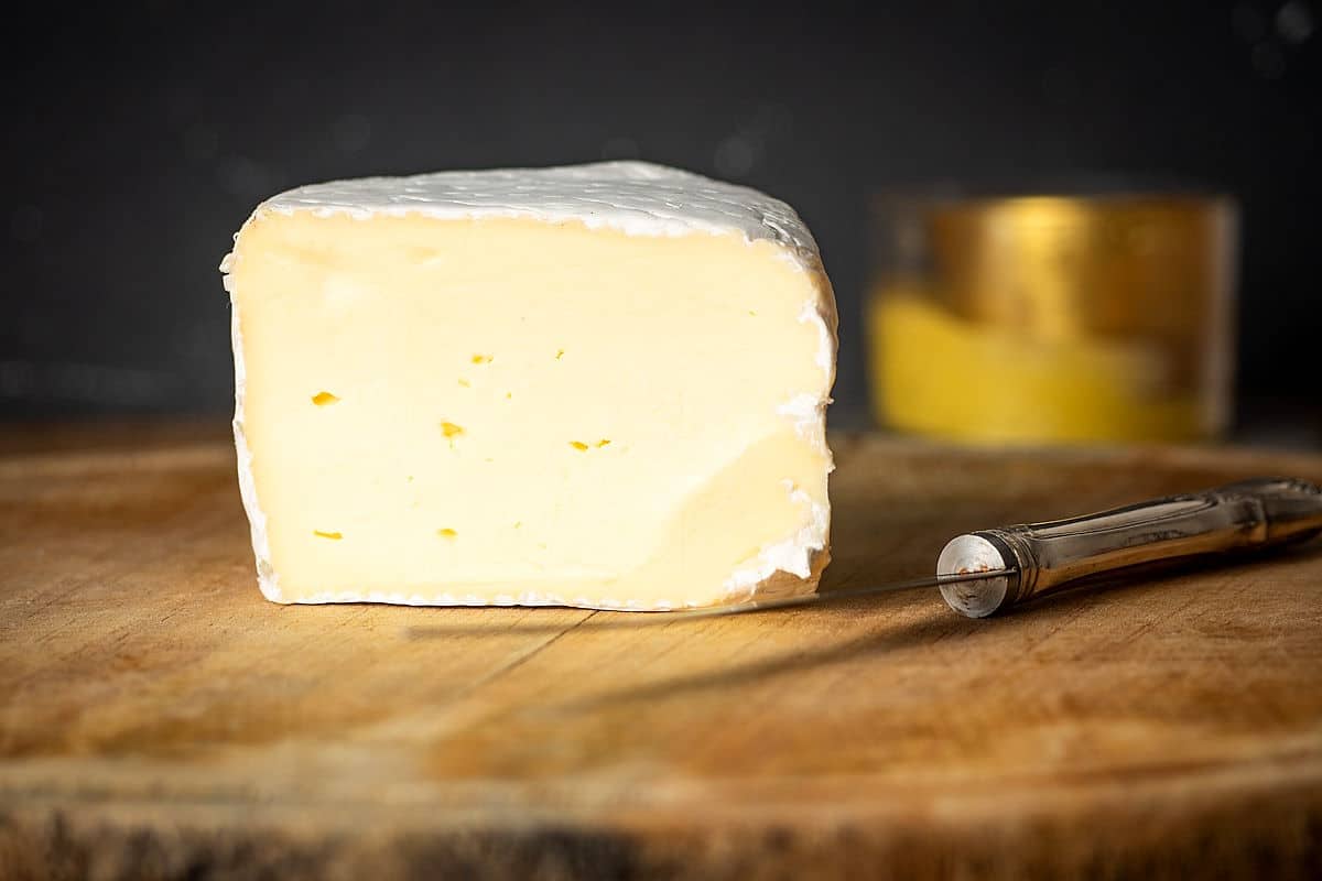 Brie cheese on wooden board.