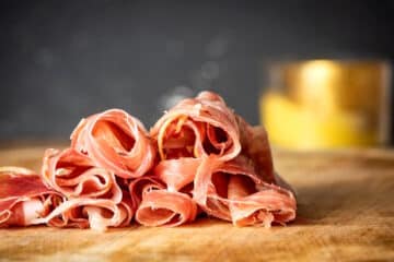 Prosciutto on wooden board.