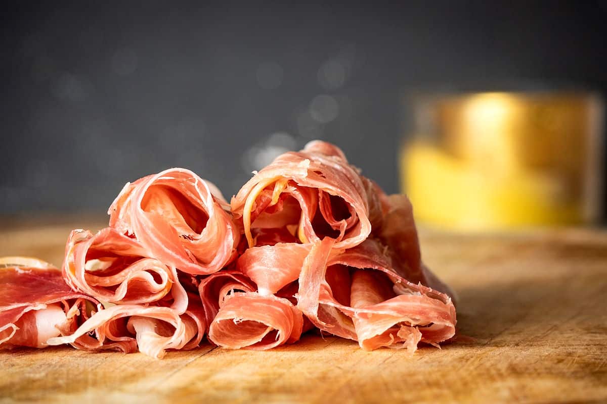 Prosciutto on wooden board.