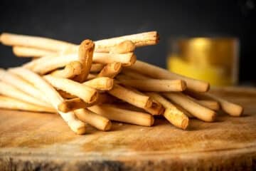 Breadsticks on wooden board.