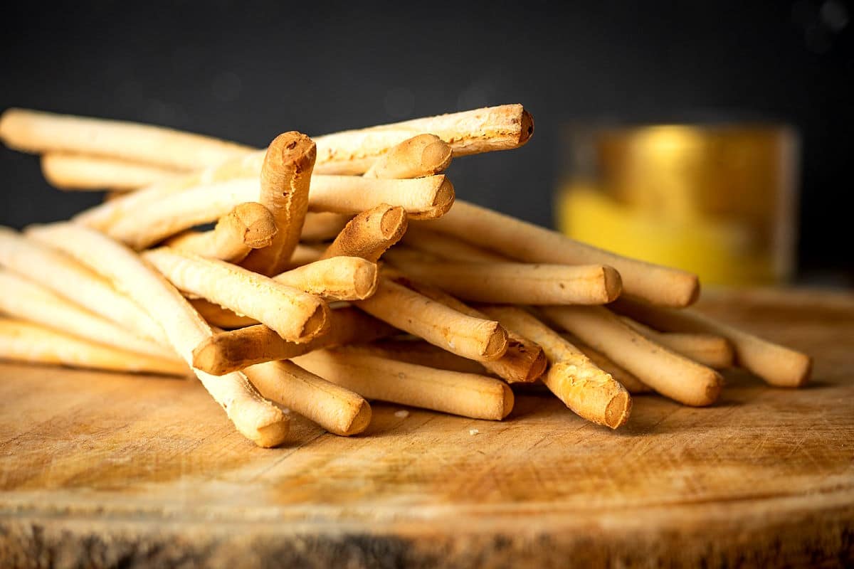 Breadsticks on wooden board.
