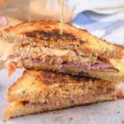 Reuben sandwiches stacked on each other with a toothpick.