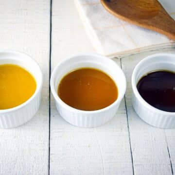 3 colors of roux in ramekins on white wooden background.