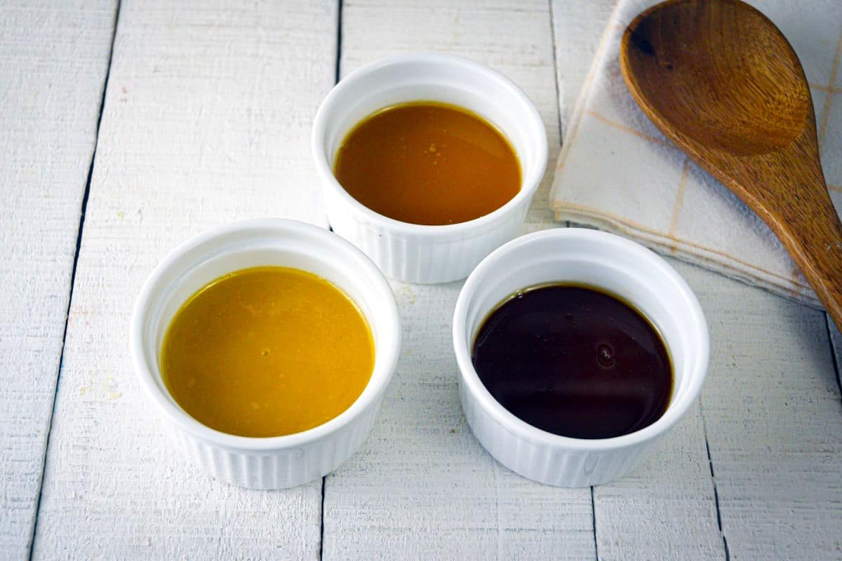 3 colors of roux in ramekins on white wooden background.