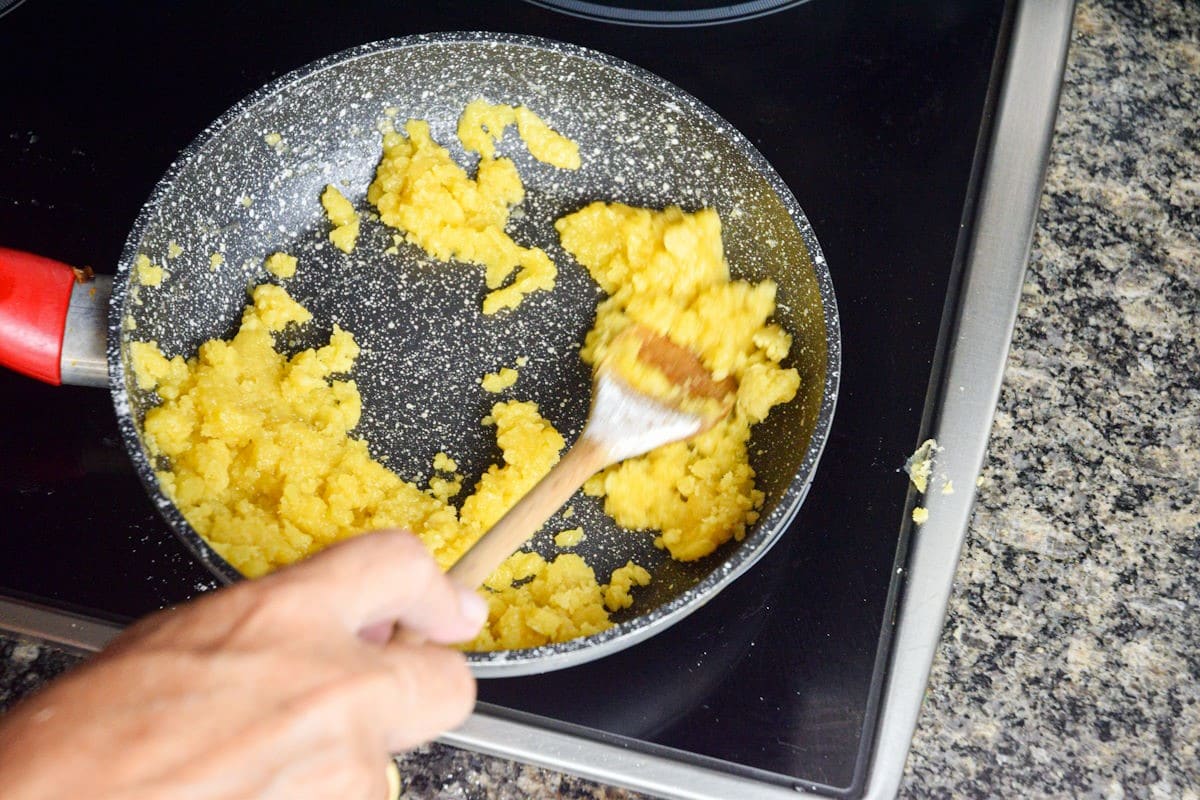 White roux in pan with wooden spoon.