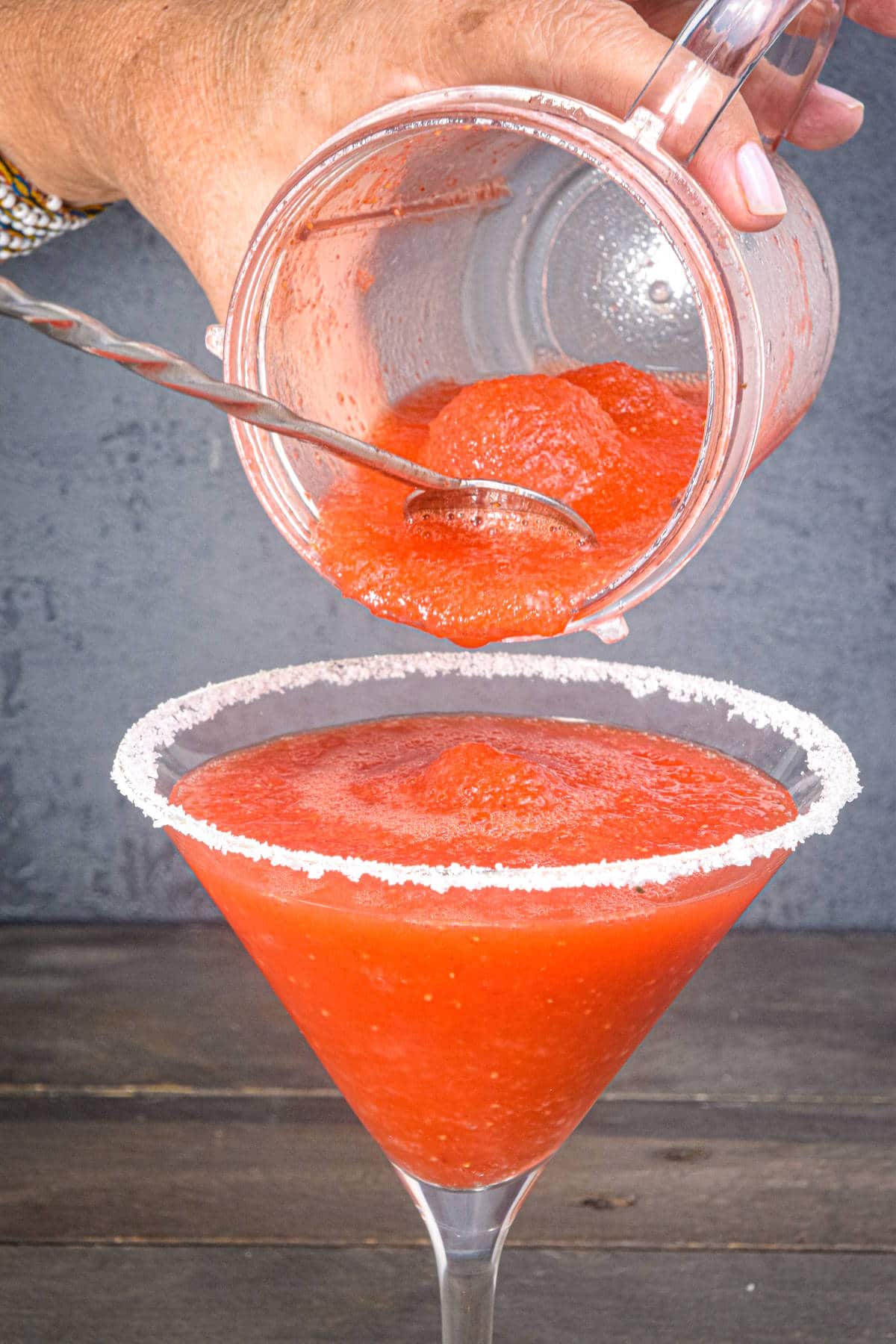 Slushy margarita pouring into martini glass.
