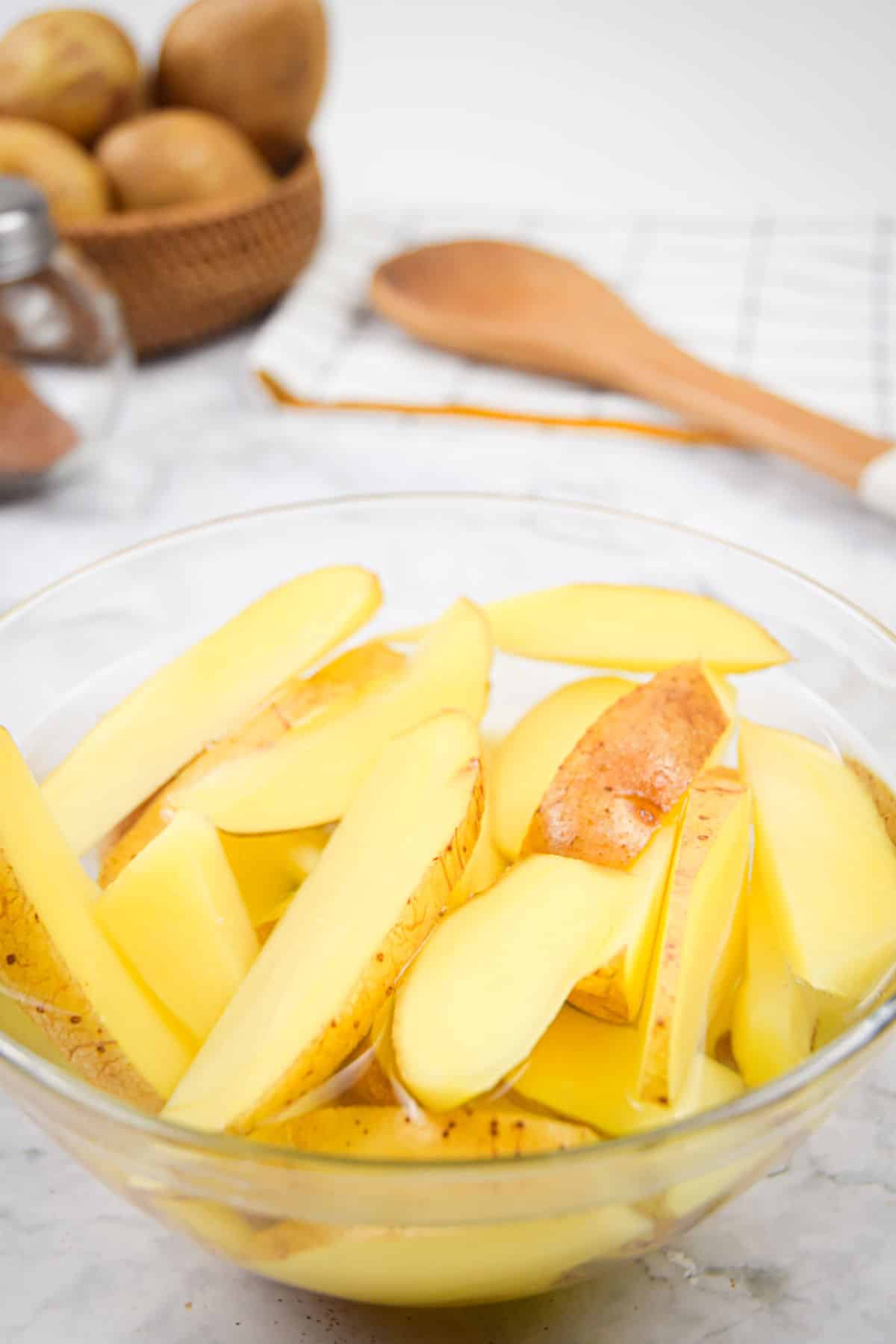 Potato wedges in bowl of hot water.